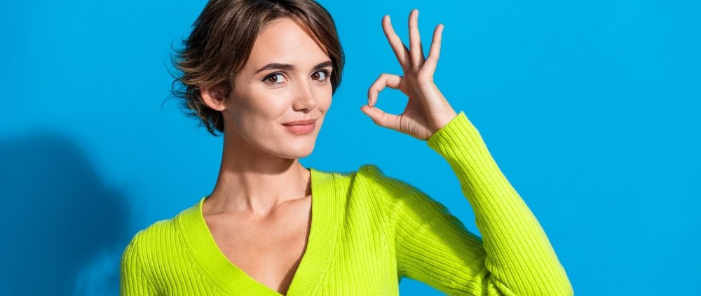 a woman who indicates with the OK sign she understands the role of paid content in public relations