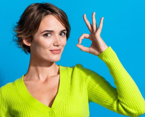 a woman who indicates with the OK sign she understands the role of paid content in public relations