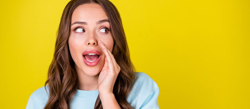 Photo of a young woman with her hand cupping her face and looking to the side