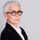 Portrait of an older, professional woman with her arms crossed.