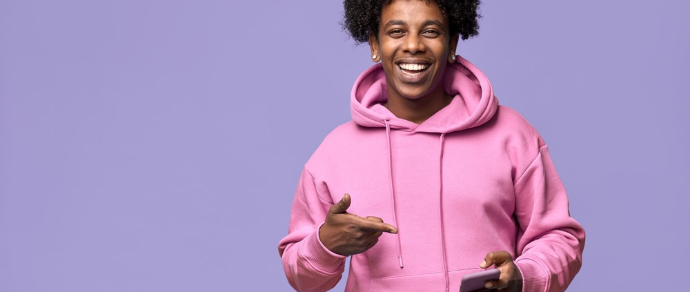Happy,Cool,African,American,consumer product founder,Guy,Teen,Boy,Model,Wearing,Pointing at media coverage on phone,