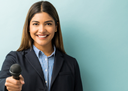 A young female journalist in a casual suit.