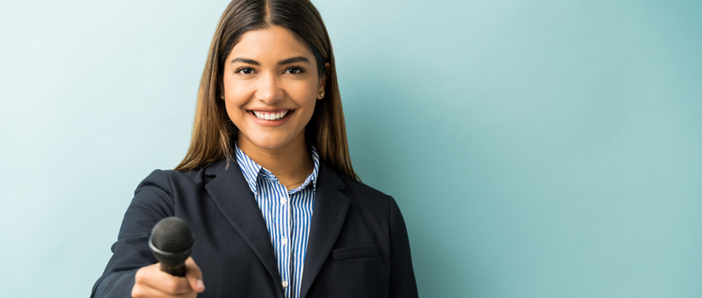A young female journalist in a casual suit.