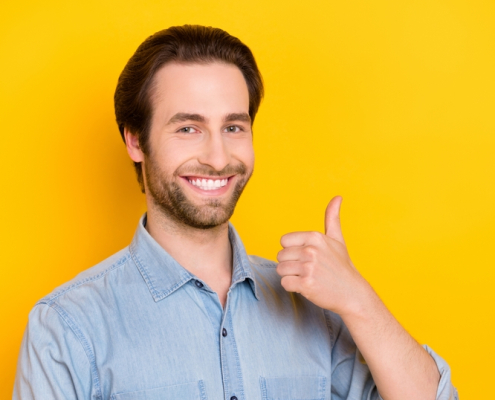 Photo of a young man looking positive, giving the thumbs up