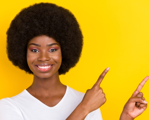 Photo of a happy woman pointing her fingers upward